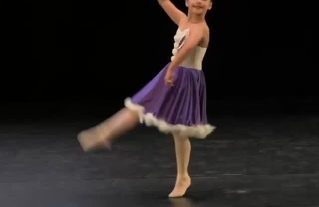 Alumna de Ballet Brío bailando en escenario con vestido morado.