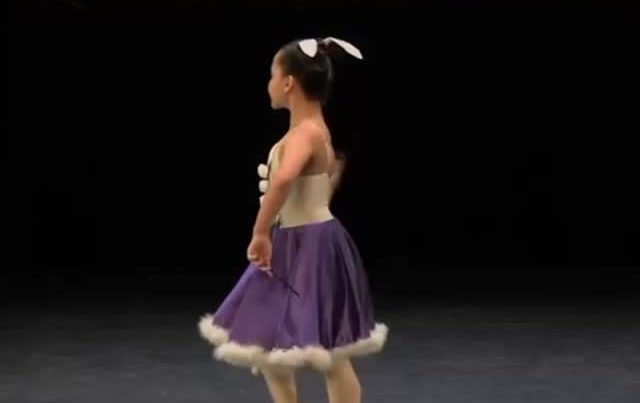 Alumna de Brío en escena con vestido morado.